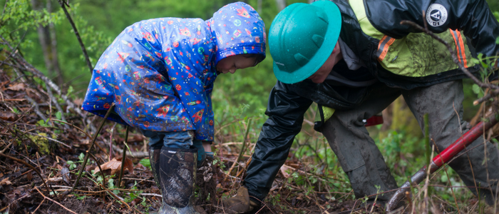 A child and adult work together to reforest an urban area