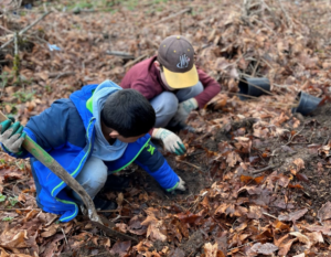 Students from Roxhill at E.C. Hughes Elementary investigating soil during a planting event hosted by DNDA.