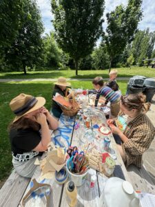 Sweet times in the sunshine with a picnic table full of art supplies and good people. Students and the teaching artist are considering how to make their next steps for their art project.