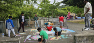 Youth start their mural design process using chalk to explore different possibilities for how the finished product could end up.