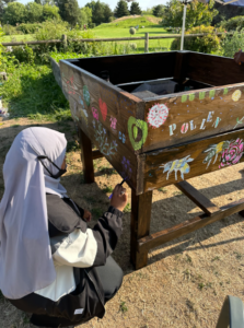 High Point teen intern adding paint onto their design that celebrates the important ace of pollinators.