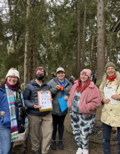 Our Winter Wings team is pictured above featuring DNDA Teaching Artist (April) and Staff (Jules) and SPR Environmental Education team of Seattle Urban Nature Guides and Community Naturalist (Nicole). The group is smiling and some hold up the tools used – scavenger identification, binoculars, and a laminated identification guide for looking for birds.