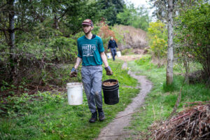 Volunteers carrying dirt and plants to help out.