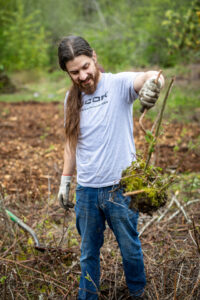 Nucor volunteer at Earth Day event holding up a plant.