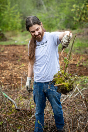 Nucor volunteer at Earth Day event holding up a plant.